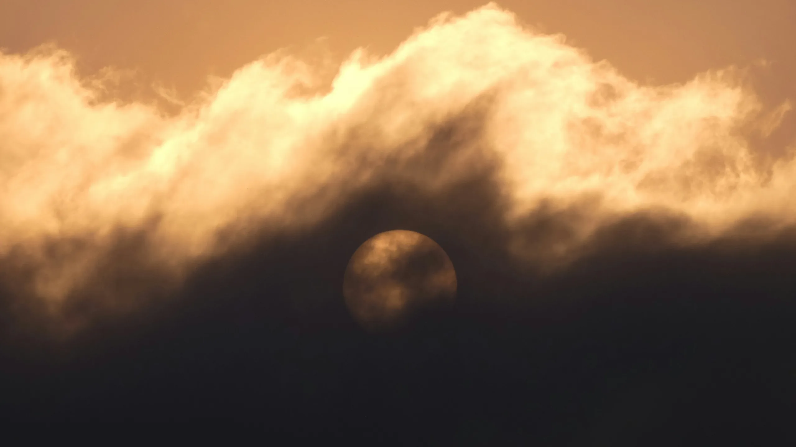 Smoke from wildfire with clouds covering the sun. Airdrie, Alberta, Canada.